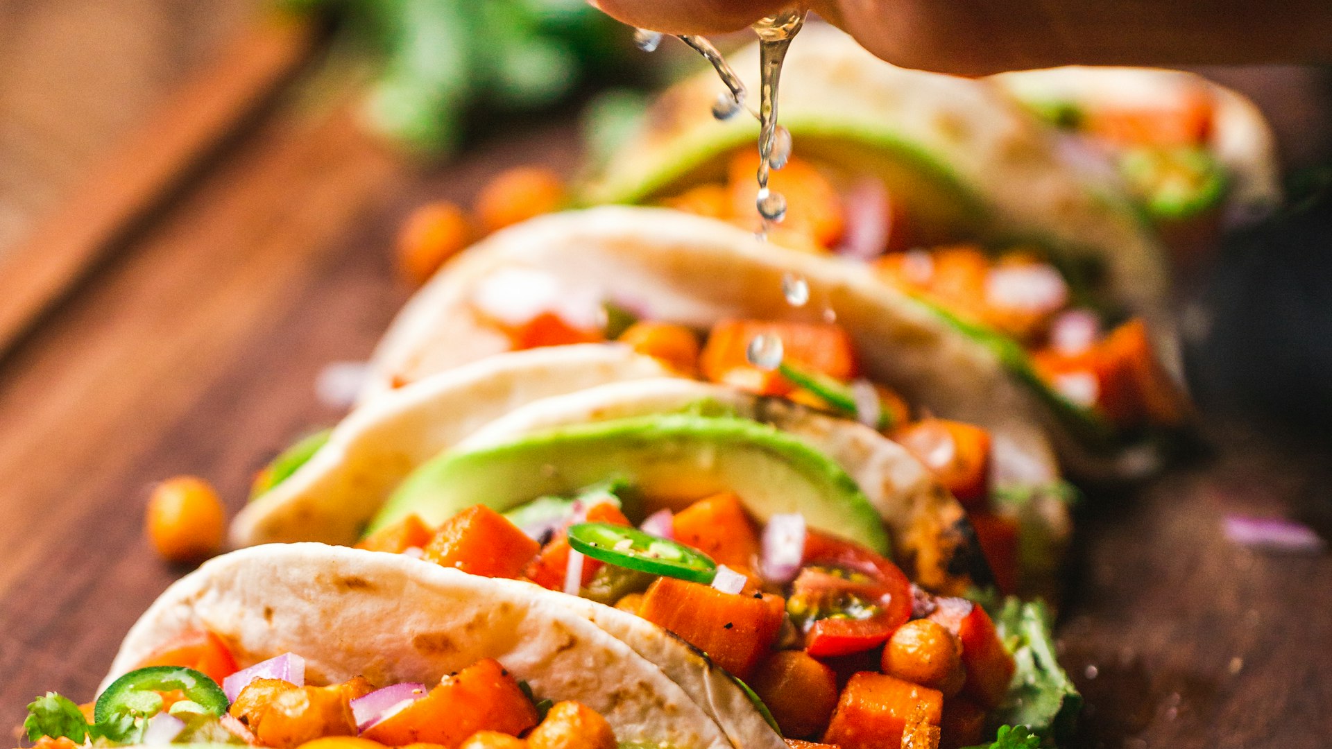 Hand-pressed street tacos loaded with carne asada and salsa verde on the Fuego Street Kitchen serving line