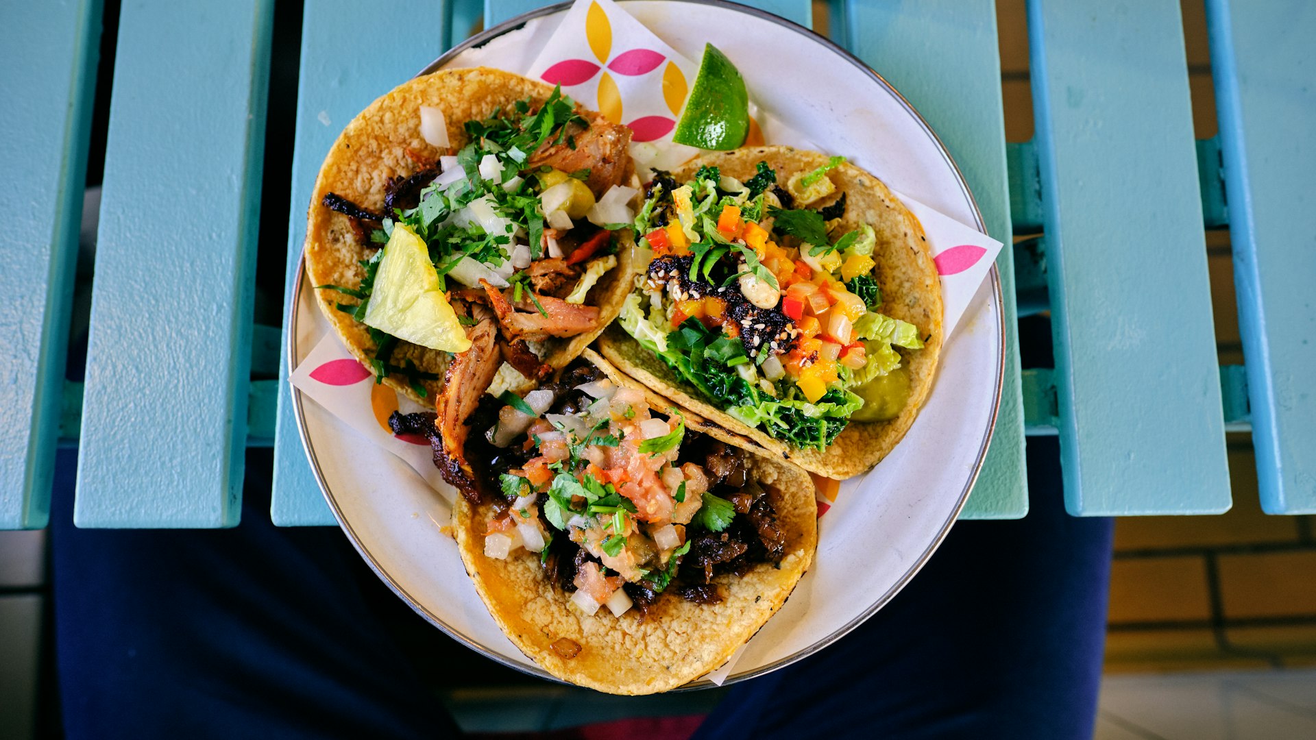 Birria tacos plated with a small cup of consommé for dipping